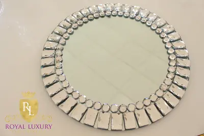 Mirrored charger with faceted rectangular and round jewels around the edge, photographed at an angle