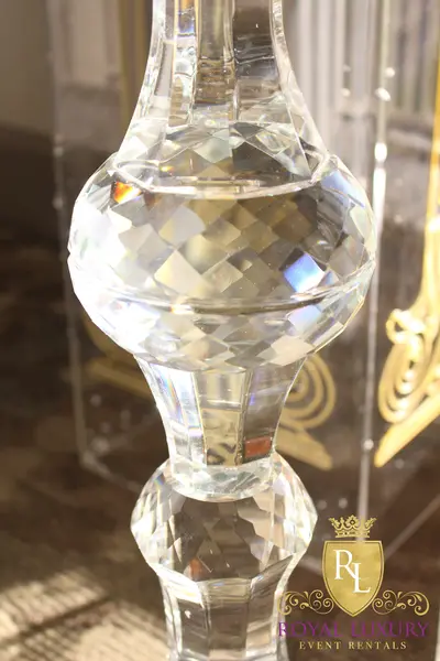 Close-up of faceted crystal stem sections on a candelabra, with gold-etched clear pillars blurred behind