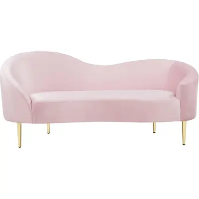 Curved loveseat in blush pink suede with a low wavy back and slim gold legs, front view