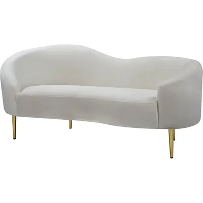 Cream suede curved loveseat with slim gold legs, shown at a three-quarter angle