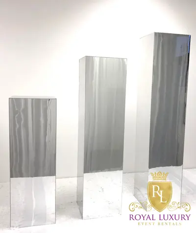 Set of three plain silver mirrored stands in graduated heights, shown without flowers
