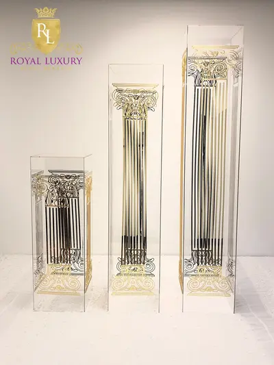 Trio of transparent acrylic stands in graduated heights, each engraved with an ornate gold column and scrollwork base