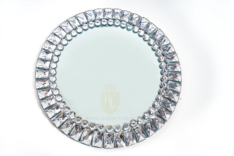 Round mirrored glass charger with a rim of faceted rectangular and round crystal-like jewels, shown flat