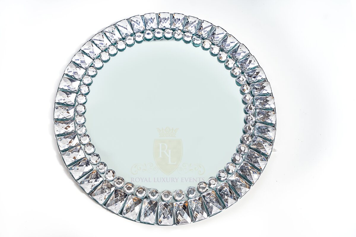Round mirrored glass charger with a rim of faceted rectangular and round crystal-like jewels, shown flat
