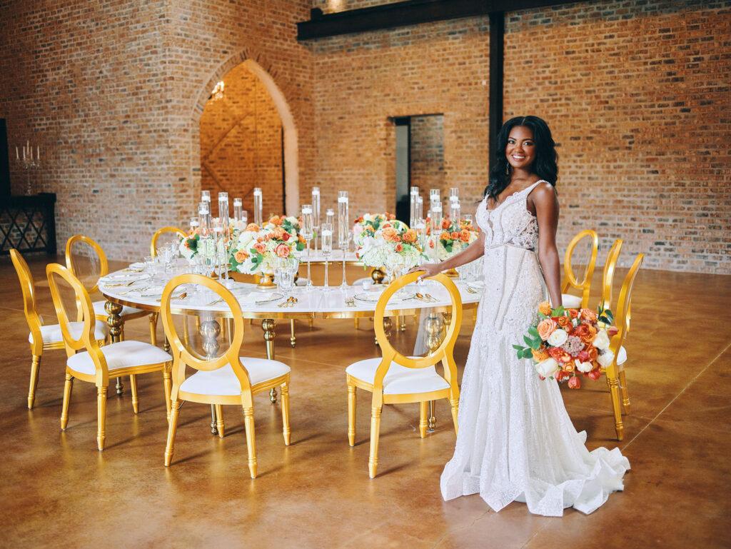 gold round table for wedding reception, with bride holding colorful bouquet in a-line wedding dress