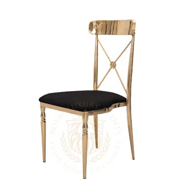 Cross-back chair with polished gold metal frame and black velvet seat, shown at a three-quarter angle