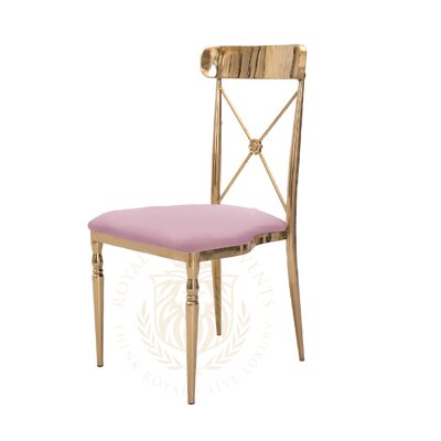 Cross-back chair with polished gold metal frame and blush pink velvet seat, shown at a three-quarter angle