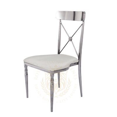 Cross-back chair with polished silver metal frame and white seat cushion, shown at a three-quarter angle