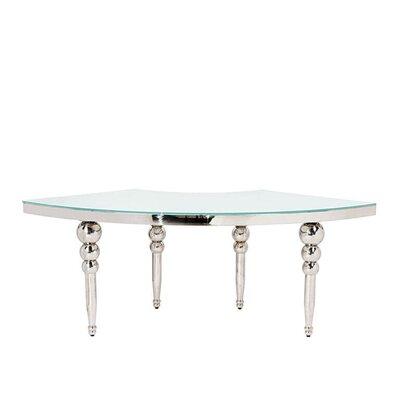 Single quarter section of a silver serpentine table with polished bubble legs and a pale glass top, front view