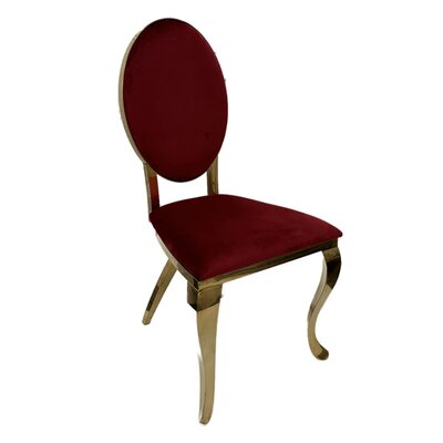 Gold oval-back chair upholstered in ruby red velvet, shown at an angle