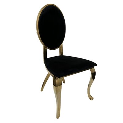 Gold chair with oval black velvet back and seat on curved gold legs, angled view