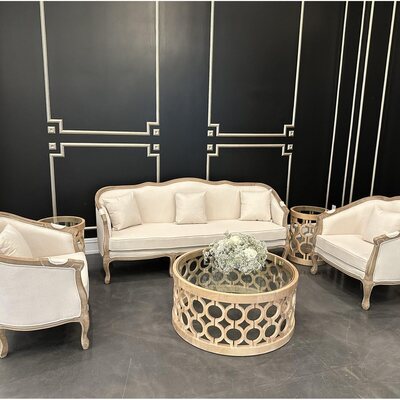 Off-white curved-back sofa between two matching armchairs in a lounge set at Sandlewood Manor
