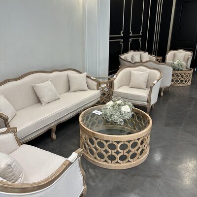 Off-white sofa and armchairs grouped around lattice coffee tables, viewed inside at Sandlewood Manor