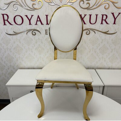 Gold oval-back chair with white velvet cushion, front view, on a round white table before a damask wall