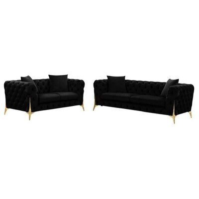 Black tufted velvet three-seater and two-seater sofas with gold legs, shown side by side with scatter cushions